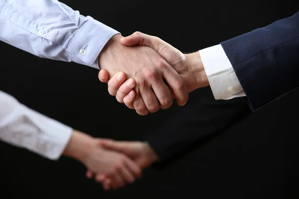 Business handshake on dark background — Stock Photo, Image