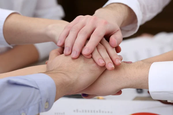 Mani unite del team aziendale sullo sfondo dello spazio di lavoro — Foto Stock