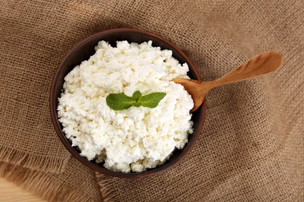 Queso de cabaña en un tazón sobre fondo de saco —  Fotos de Stock