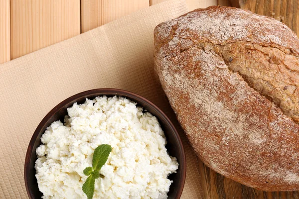 Hüttenkäse in Schüssel mit Brot auf dem Tisch aus nächster Nähe — Stockfoto