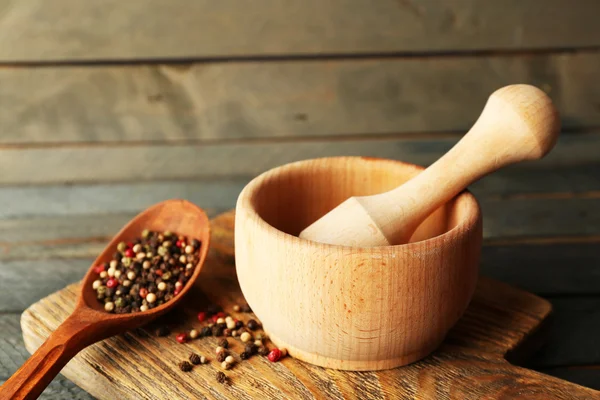 Mezcla de pimientos en mortero sobre fondo de madera — Foto de Stock