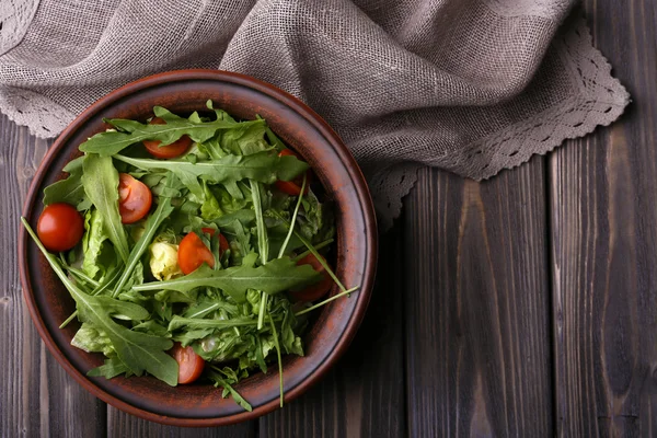 Salada com arugula e tomate cereja em mesa de madeira — Fotografia de Stock