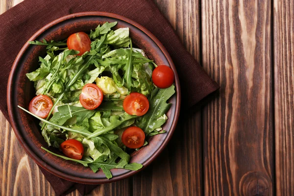 Ensalada con rúcula y tomates cherry sobre mesa de madera — Foto de Stock