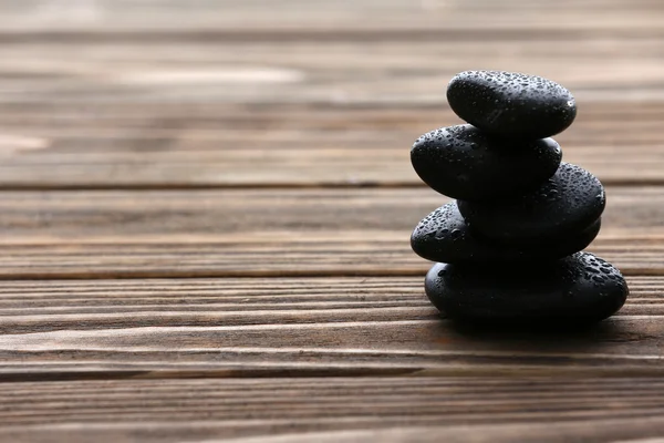 Spa stones with water drops on wooden background — Stock Photo, Image