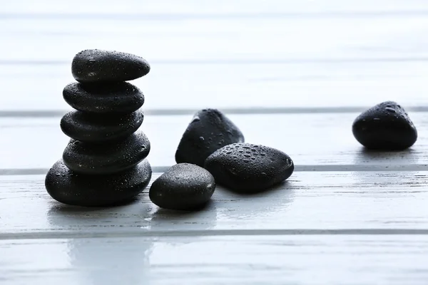 Spa stones with water drops on wooden background — Stock Photo, Image