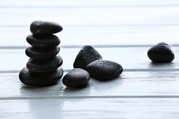 Spa stenen met water druppels op houten achtergrond — Stockfoto