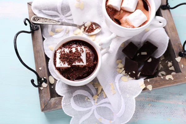 Hot chocolate with marshmallows in mug, on tray, on color wooden background — Stock Photo, Image