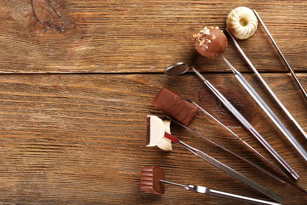 Tandläkare verktyg med godis på trä bakgrund — Stockfoto