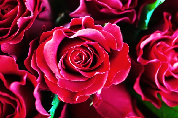 Beautiful red roses in glass vase on wooden background — Stock Photo, Image