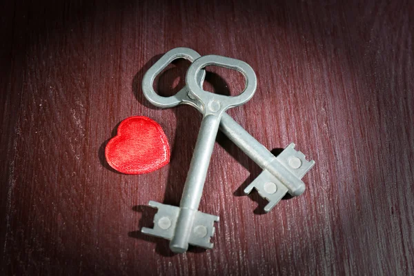 Keys with decorative heart on wooden background — Stock Photo, Image