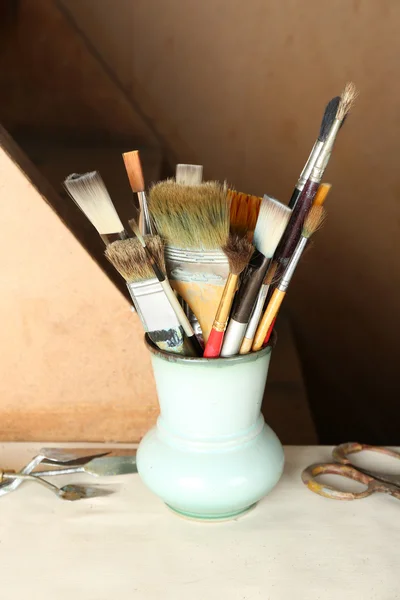 Boya fırçaları ahşap arka plan üzerinde vazoda — Stok fotoğraf