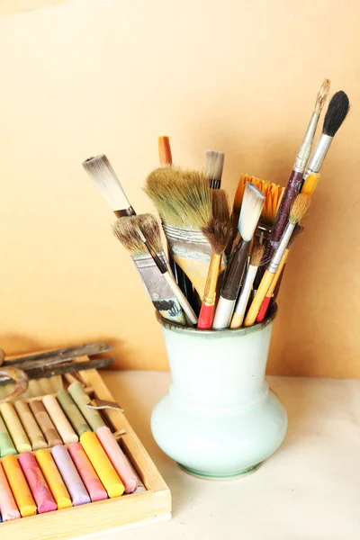 Paintbrushes with colorful chalk pastels in box on wooden background — Stock Photo, Image