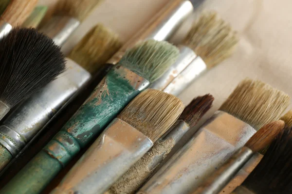 Different paintbrushes on fabric background — Stock Photo, Image