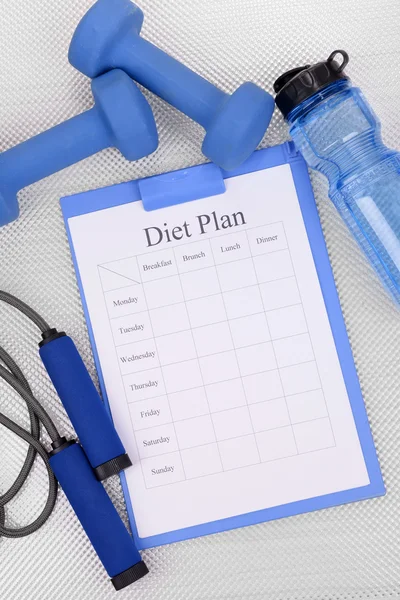 Diet plan and sports equipment top view close-up