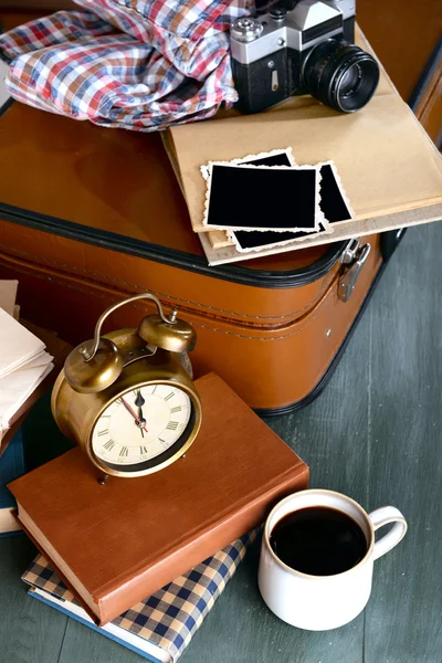 Maleta vintage con ropa y libros sobre fondo de madera — Foto de Stock