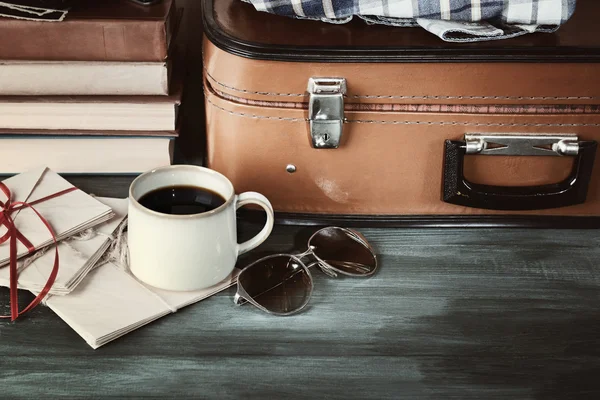 Maleta vintage con ropa y libros sobre fondo de madera — Foto de Stock