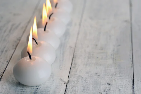 Brennende Kerzen auf Holztisch in Großaufnahme — Stockfoto