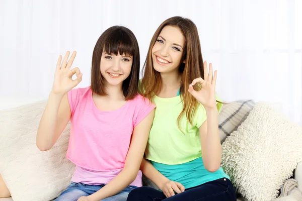 Dos chicas sonriendo en el fondo interior de casa — Foto de Stock