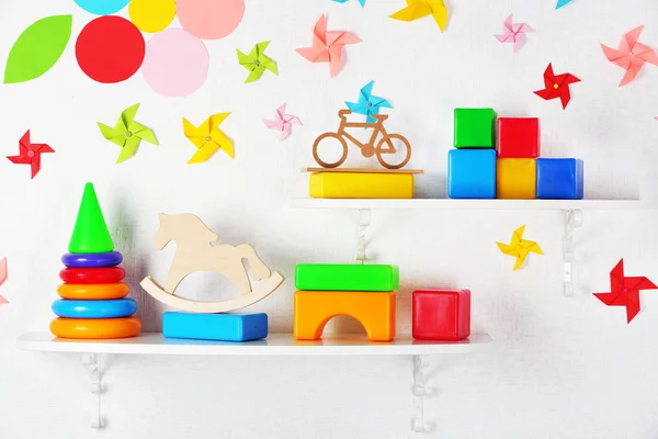 Planken met speelgoed in kinderkamer close-up — Stockfoto