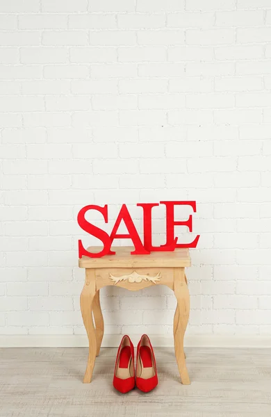 Försäljning med skor på sidobord i rum — Stockfoto