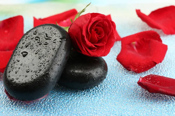 Spa stones and rose petals on colorful background Royalty Free Stock Photos