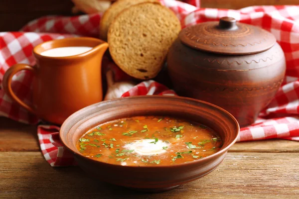 Ukrainian beetroot soup - borscht in bowl and pot, on napkin, on wooden background — Stock Image Ukrainian beetroot soup - borscht in bowl and pot, on napkin, on wooden background Stock Picture