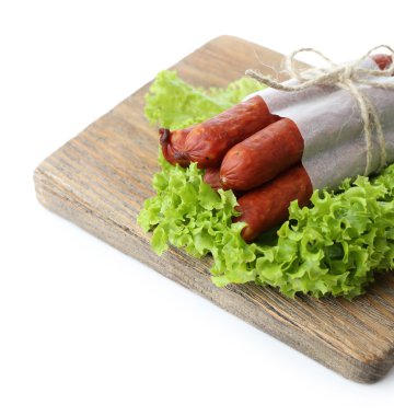 ahşap kesme tahtası, üzerinde beyaz izole marul salata yaprakları ile ince Sosis füme