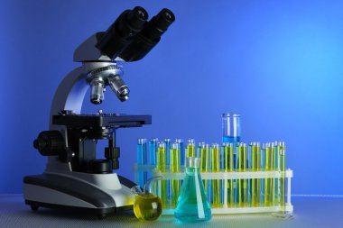 Mikroskop ve masaya renk arka plan üzerinde test tüpleri