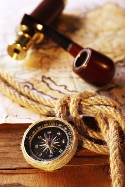 Marine still life with world map and rope on wooden table background clipart