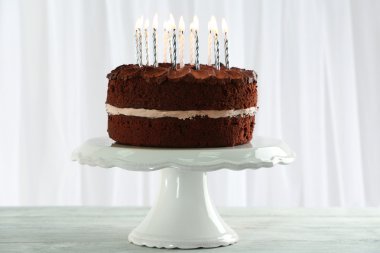 Masada açık renkli mum ile lezzetli çikolatalı kek