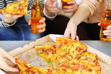 Arkadaşlar el ile şişe bira ve pizza, yakın çekim
