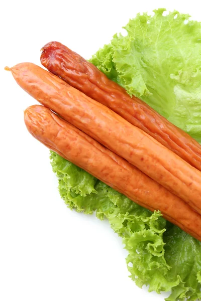 Smoked thin sausages  with lettuce salad leaves, isolated on white — Stock Photo, Image