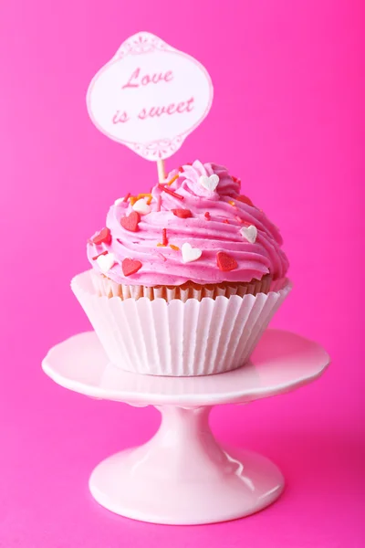 Delicious cupcake with inscription on pink background — Stock Photo, Image