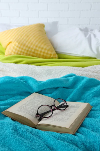 Libro y gafas en la cama de primer plano — Foto de Stock