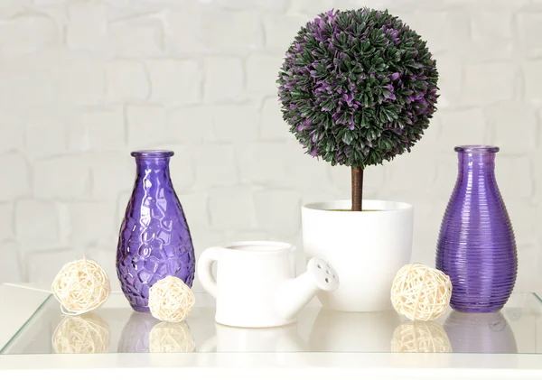 Interior with decorative vases and plant on table top and white brick wall background — Stock Photo, Image