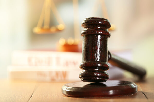 Wooden judges gavel on wooden table, close up