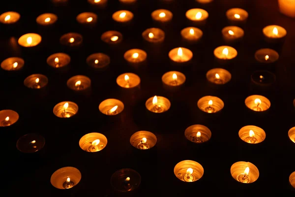 Зажигание свечей на тёмном фоне — стоковое фото