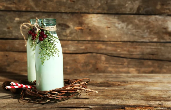 Bouteilles de lait frais au décor naturel, sur fond de bois — Photo