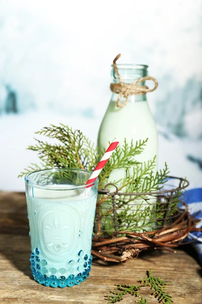 Fresh milk with natural decor, on wooden table, on winter background — Stock Photo, Image