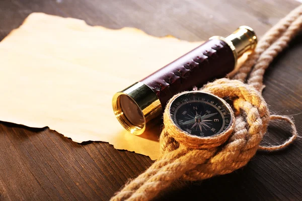 Spyglass morskich martwa, kompas lina i arkusz papieru na drewniane tła — Zdjęcie stockowe