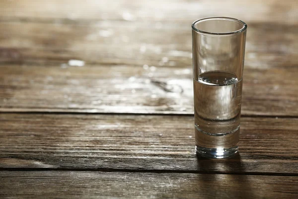 素朴な木製の板の背景にきれいなミネラル水のガラス — ストック写真