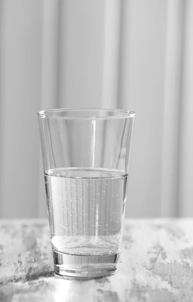 Glass of clean mineral water on old color wooden surface and planks background — Stock Photo, Image