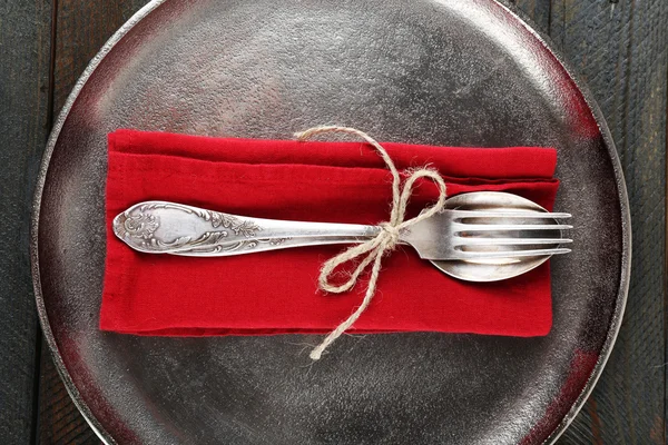 Silverware tied with rope on red napkin and metal tray on wooden background — Stock Photo, Image