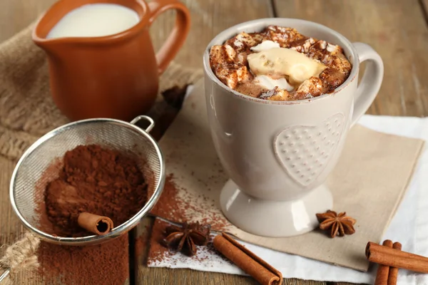 Tazza di caffè caldo con marshmallow e tazza di latte con cannella, anice stellato e colino di cacao su tovagliolo e fondo tavola rustico in legno — Foto Stock