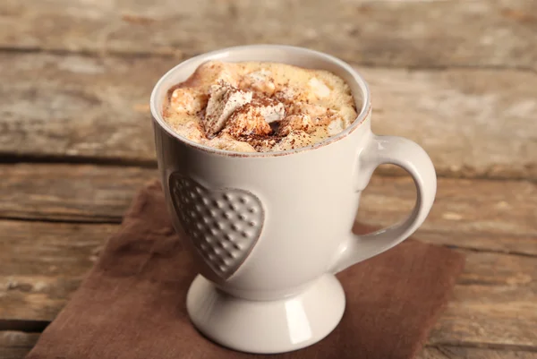 Tazza di caffè caldo con marshmallow su tovagliolo e tavolette di legno rustico sfondo — Foto Stock