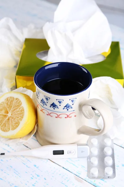 Gorąca herbata na przeziębienia, pigułki i serwetki na stół szczegół — Zdjęcie stockowe