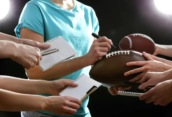 Autographs by American football star on black and lights background