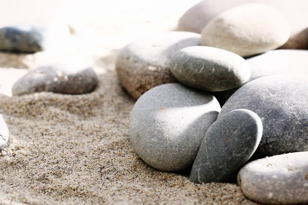 砂の背景に灰色の海の小石 — ストック写真