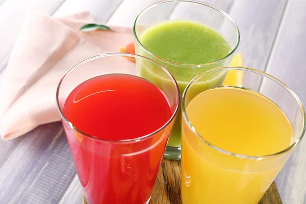 Fresh juices with fruits on wooden table — Stock Photo, Image