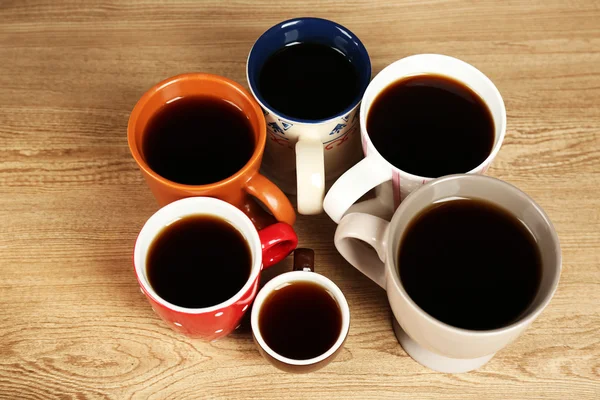 Molte tazze di caffè su sfondo tavolo in legno, vista da vicino — Foto Stock